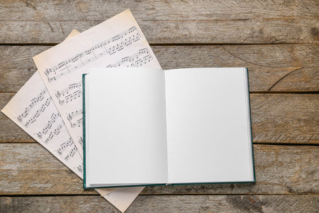 Blank open book and music notes on wooden background