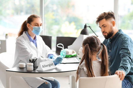 Little girl and her father visiting allergist in clinicの写真素材