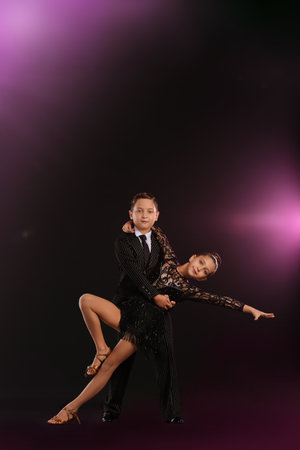 Cute little children dancing against dark backgroundの写真素材