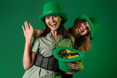 Young women with leprechaun's hat on green background. St. Patrick's Day celebrationの写真素材