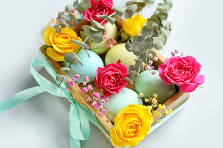 Composition with painted Easter eggs, beautiful flowers and eucalyptus branches on white background, closeupの写真素材