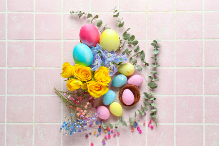 Composition with painted Easter eggs, beautiful flowers and eucalyptus branches on color tile...