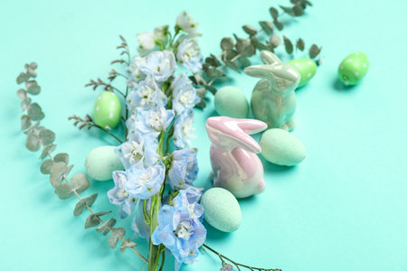 Composition with Easter eggs, ceramic bunnies and beautiful flowers on color background, closeupの写真素材