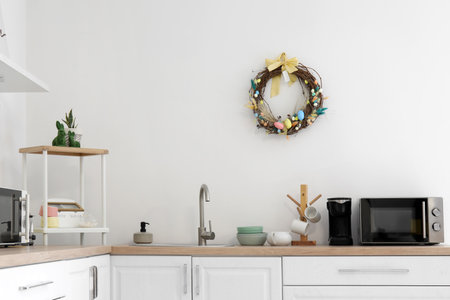 Easter wreath hanging on light wall in interior of kitchen