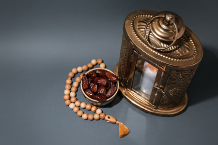 Muslim lantern with burning candle, prayer beads and dates for Ramadan on dark backgroundの写真素材