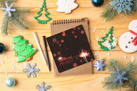 Beautiful greeting card for Christmas celebration, notebook and decor on wooden backgroundの写真素材