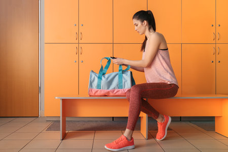 Woman with sport bag in gym locker roomの写真素材