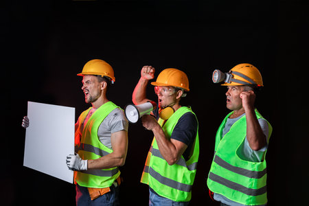 Protesting miner men with placard on dark backgroundの写真素材