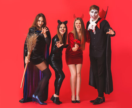 Friends in Halloween costumes on color backgroundの写真素材