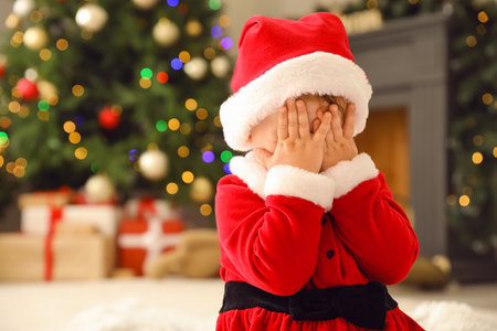 Cute little baby in Santa costume at home on Christmas eveの写真素材