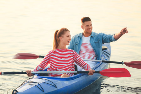 Young couple kayaking in riverの写真素材