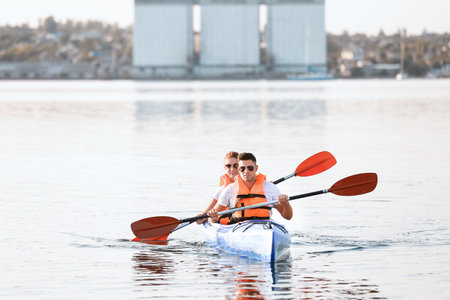 Young couple kayaking in riverの写真素材