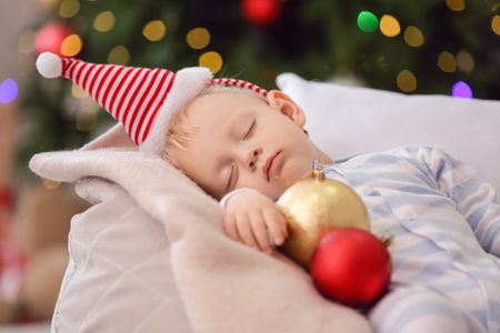 Cute little baby in Santa hat sleeping at homeの写真素材
