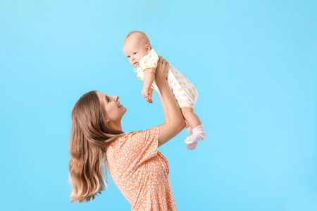 Happy mother with cute little baby on color background