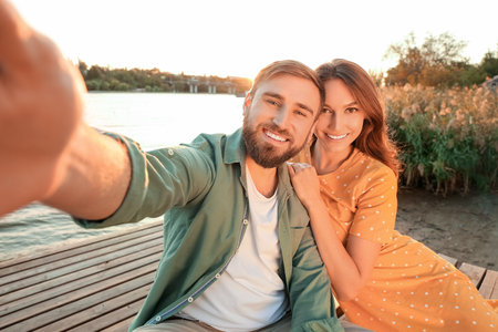 Young couple taking selfie near the riverの写真素材