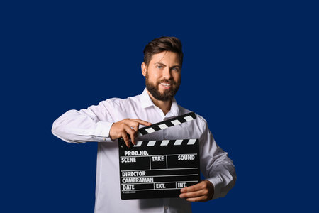Man with movie clapper on color background