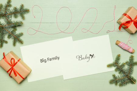 Paper sheets with different goals, figure 2021 and Christmas gifts on color wooden background