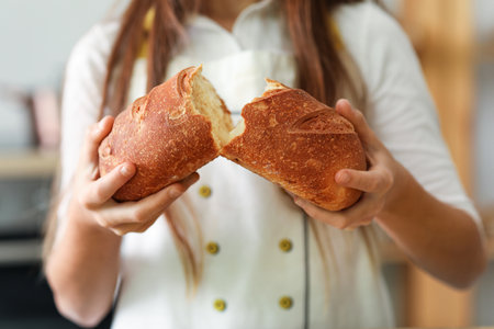 Little baker with fresh bread in kitchen, closeupの写真素材