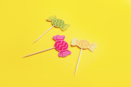 Stylish cupcake toppers on color background