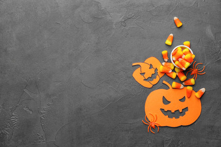 Halloween composition with tasty candy corns on dark background