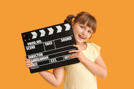 Little girl with movie clapper on color backgroundの写真素材