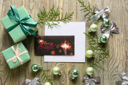 Beautiful composition with Christmas greeting card on wooden background