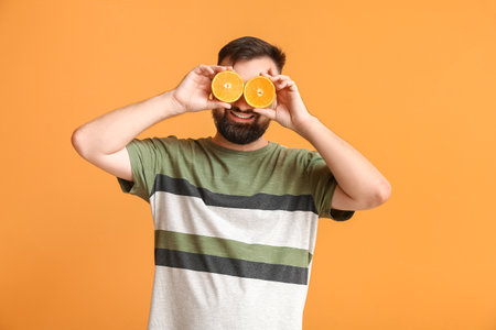 Funny man with orange on color backgroundの写真素材