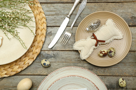 Table setting with Easter eggs, bunny and cutlery on wooden backgroundの写真素材