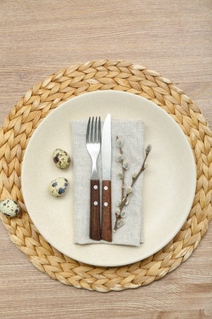 Table setting with Easter eggs and pussy willow branches on wooden background