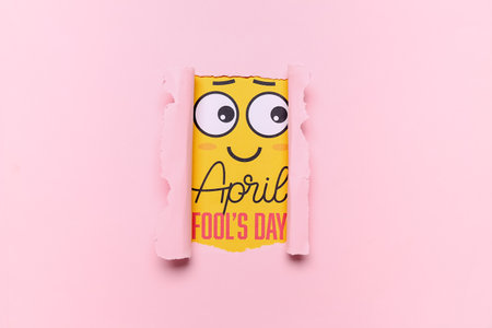 Card with text APRIL FOOL'S DAY visible through torn color paperの写真素材
