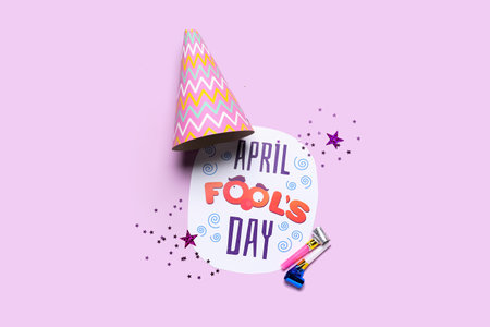 Composition with text APRIL FOOL'S DAY, party hat and whistles on color backgroundの写真素材