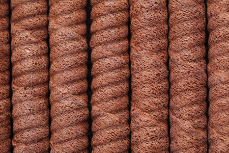 Delicious chocolate wafer rolls as background