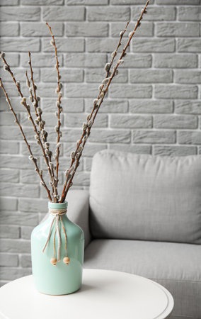 Vase with willow branches on table in modern living roomの写真素材