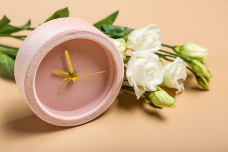Alarm clock and beautiful eustoma flowers on color background, closeup