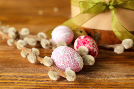 Painted Easter eggs and willow branches on wooden table, closeup