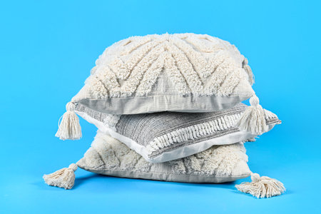 Stack of soft pillows on blue background