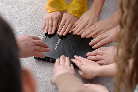 Group of people praying with Holy Bible on floor, closeupの写真素材