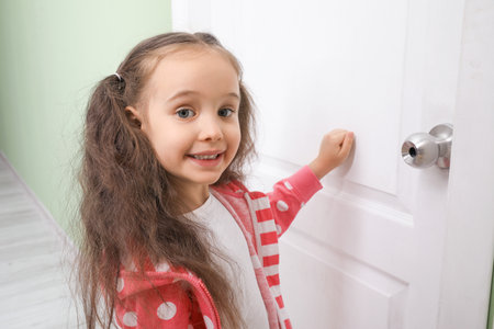 Cute little girl knocking at the doorの写真素材