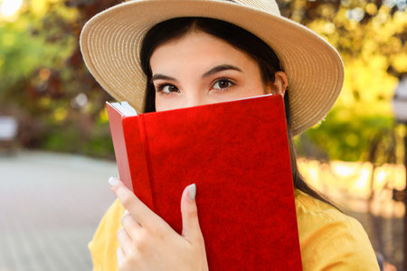 Beautiful young woman reading book in parkの写真素材
