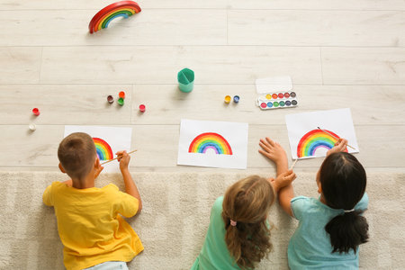 Little children painting rainbow during Covid-19 quarantine at home, top viewの写真素材