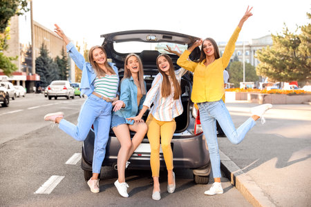 Happy young women near modern carの写真素材