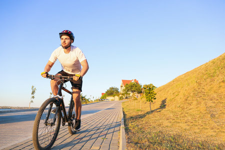 Male cyclist riding bicycle outdoorsの写真素材