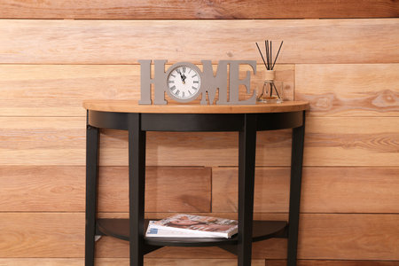 Table with decor near wooden wall in room