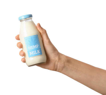 Female hand with bottle of hemp milk on white backgroundの写真素材