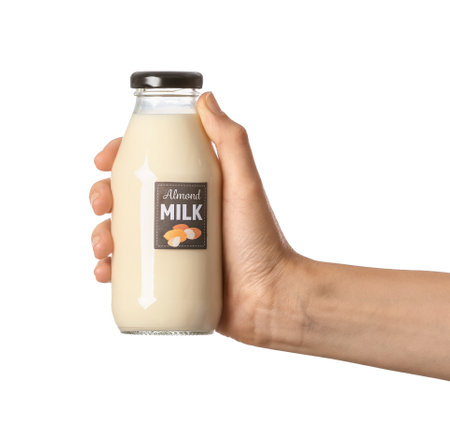 Female hand with bottle of almond milk on white backgroundの写真素材