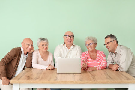 senior people video chatting at table in roomの写真素材