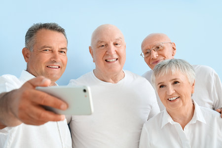 senior people taking selfie on color background
