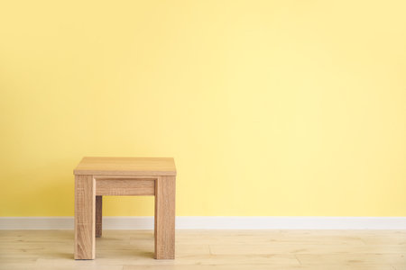 Small wooden table near color wallの写真素材