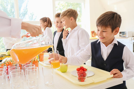 Pupils receiving lunch in school canteenの写真素材