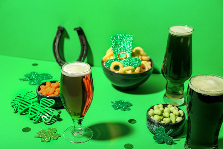 Glasses of beer, snacks and decor on green background. St. Patrick's Day celebrationの写真素材
